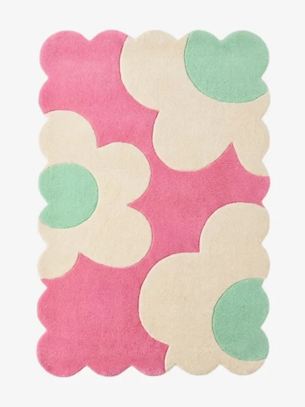 Top down view of the Blush Petalia rug featuring large abstract cream and mint green flower motifs on a vibrant pink wool background with scalloped edges.