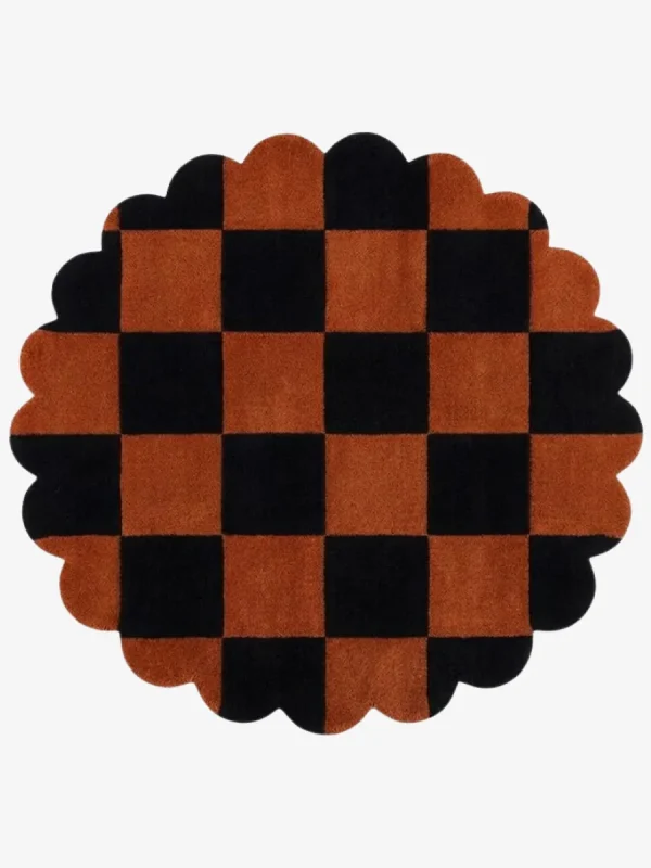 A top-down, flat lay view of the round Cinder Form rug against a grey background, showcasing its complete circular shape, abstract charcoal grey patterns over a cream field, and a continuous charcoal scalloped edge.