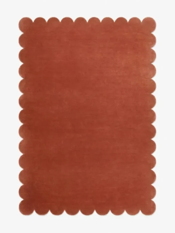 Top down view of the Clay Ember reddish brown hand tufted wool rug on a white background showing the rectangular shape and scalloped edges.