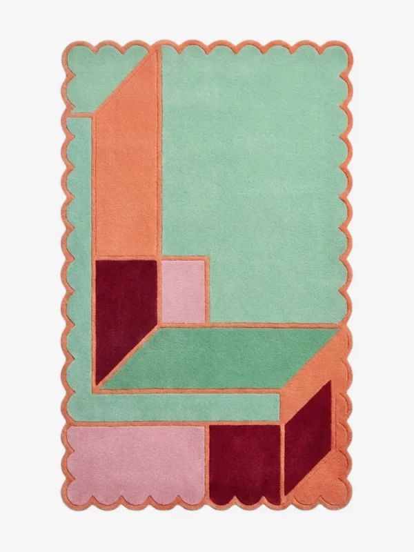 Top down view of the Coral Courtyard rug featuring an architectural geometric pattern with L-shaped blocks in fresh mint green and vibrant coral orange, finished with custom scalloped edges.