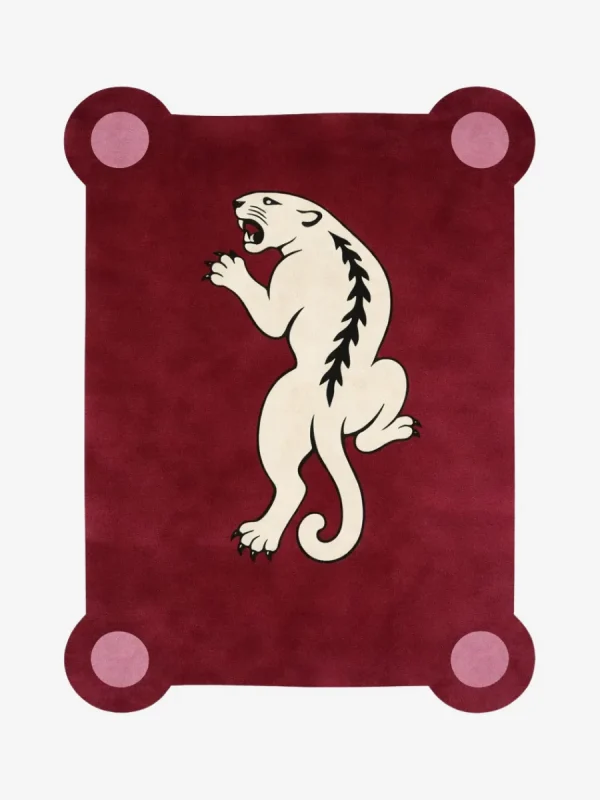 Top down view of the Crimson Prowl rug featuring a deep maroon wool background with a stylized white panther climbing design and pink circular corner accents.