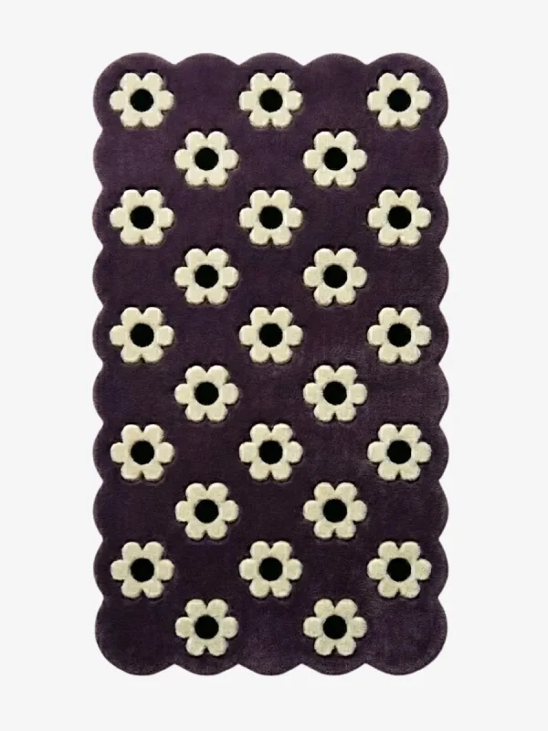 Top down view of the Daisy Night rug featuring a grid of small white daisy flowers on a deep purple wool background with scalloped borders.
