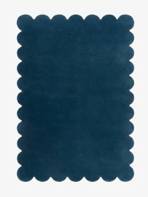 Top down view of the Deep Marine blue hand tufted wool rug on a white background showing the rectangular shape and scalloped edges.
