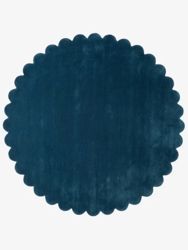 Top down flat lay of the Deepstone round wool rug showing the rich navy blue color and scalloped border.