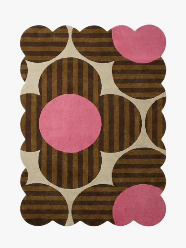 Top down view of the Dusky Bloom rug featuring a bold 1970s inspired floral pattern with brown striped petals and vibrant pink circles on a cream background.