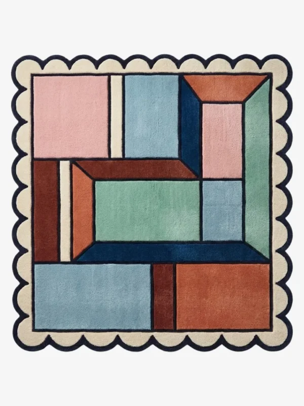 Top down view of the Dusty Dune Square rug featuring a geometric color block design in dusty blue, terracotta, and mint green, framed by a dark blue scalloped border.