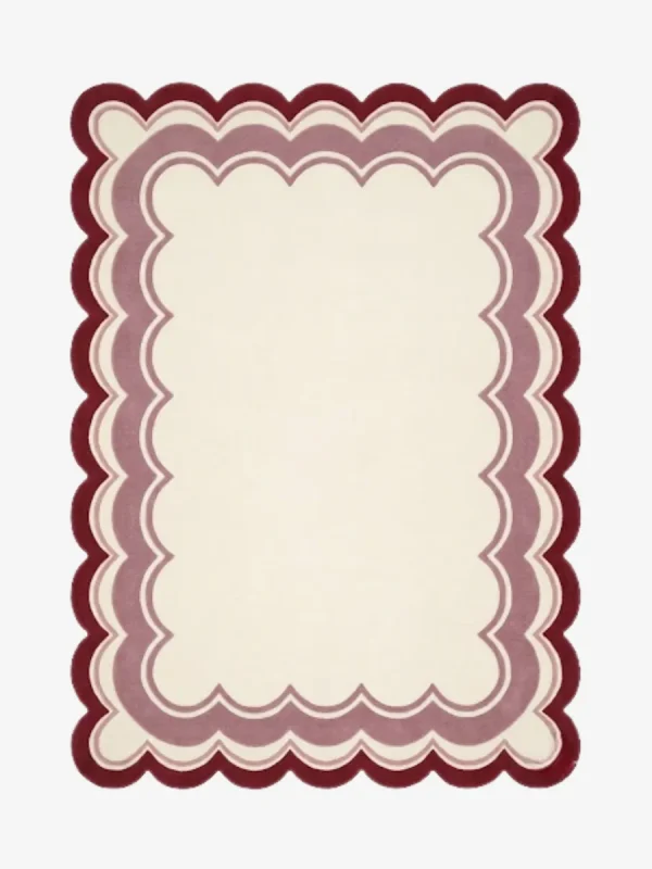 Top-down view of the rectangular Elvare Bloom rug, featuring a large cream center framed by concentric, scalloped border layers in soft pink, lavender, and a deep plum outer edge.