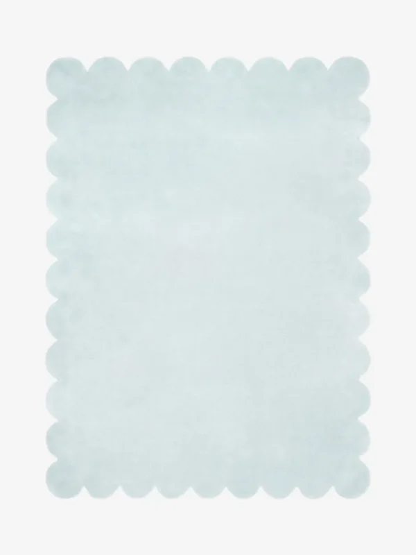 Top down flat lay of the Glacier Haze hand tufted rug featuring a calming solid ice blue color and decorative wavy edges isolated on a white background.