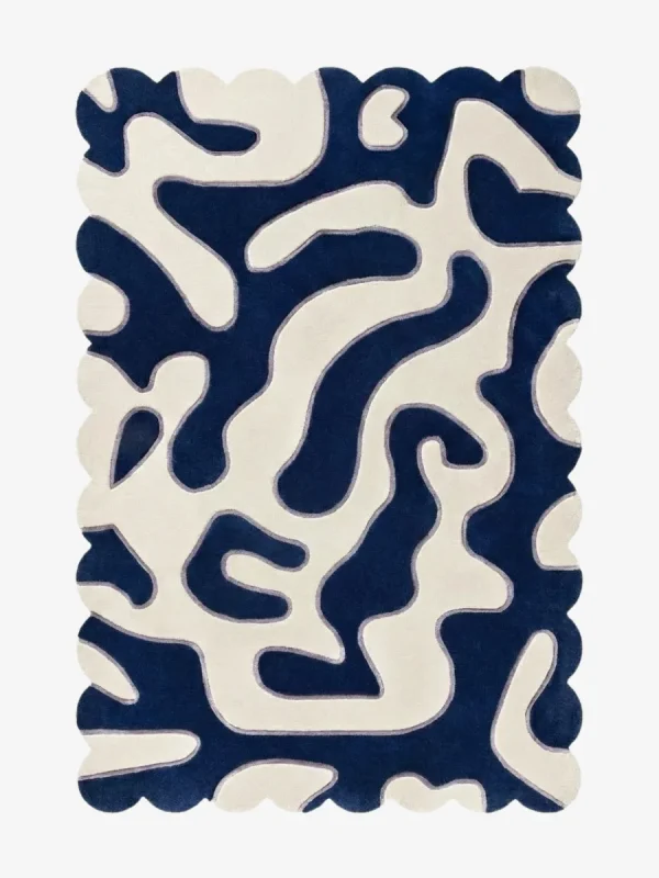 Top-down view of the Inked Dyed rug against a white background, featuring a bold, organic, maze-like abstract pattern in solid deep blue and cream, framed by a continuous scalloped border.