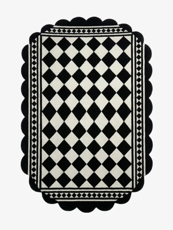 Top down view of the Ivory Lattice rug featuring a classic black and white diamond grid pattern with a geometric border and decorative scalloped edges.