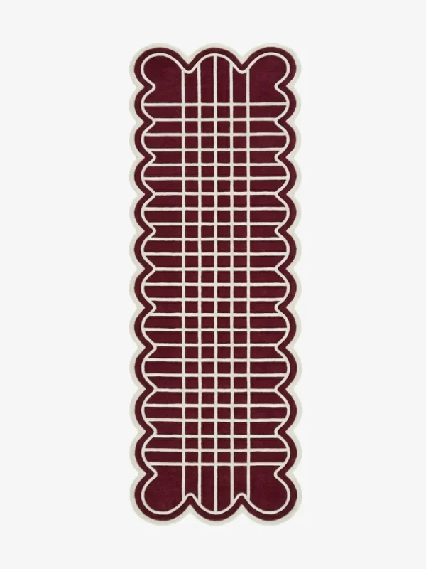 Top down view of the hand-tufted Marvion Trace Runner Rug featuring a deep burgundy background, a cream geometric grid pattern, and scalloped edges.