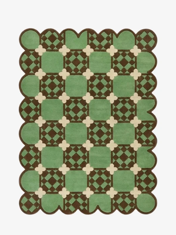 Top-down view of the Meadow Tiling rug against a white background, featuring a repeating geometric patchwork pattern of light green squares with inner brown checkered details, connected by cream cross motifs, framed by a continuous dark brown scalloped border.