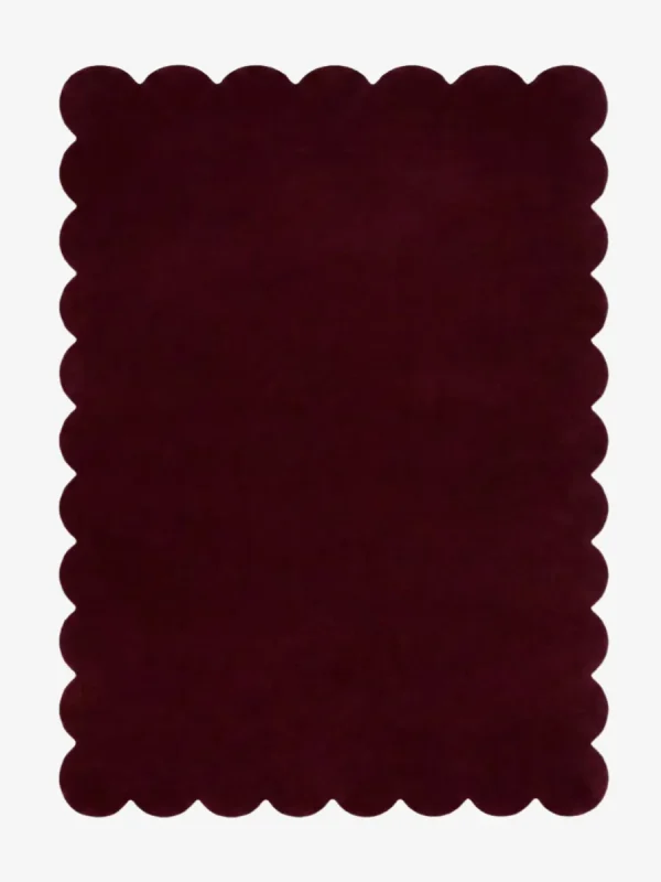 Top down view of the Merlot Plum dark purple hand tufted wool rug on a white background showing the rectangular shape and scalloped edges.