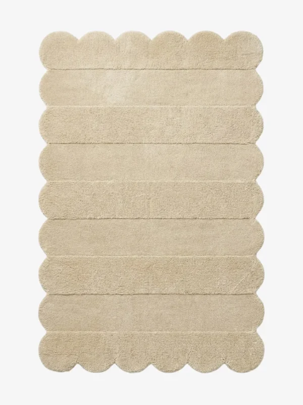 Top down view of the Milky Ridges rug featuring a solid cream color with horizontal carved textures and decorative scalloped edges.