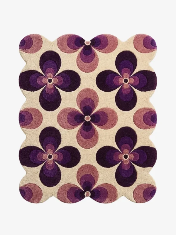 Top down view of the Mulberry Petal rug featuring a retro 70s inspired floral pattern with bold purple and lilac flower motifs on a cream wool background.