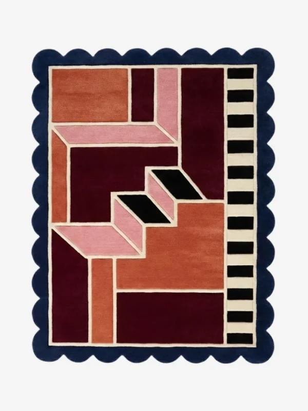 Top down view of the Muted Garnet rug featuring a sophisticated, dusty red wool background with a soft, plush texture and custom scalloped edges.