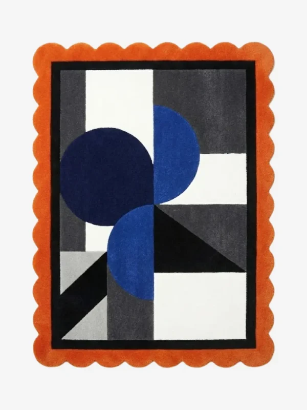 Top view of the Noctra Apex hand tufted wool rug featuring a playful orange scalloped border surrounding a modern geometric composition of navy blue circles and charcoal grey blocks on a cream background.