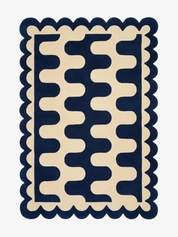 Top down view of the Obsidian Grid rug featuring a deep navy blue wool background with a bold cream wavy geometric pattern and custom scalloped edges.
