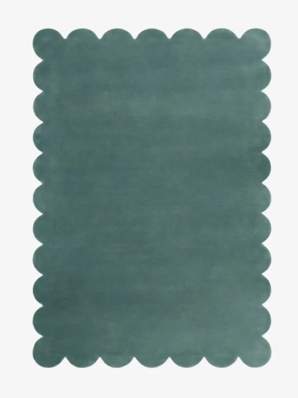 Top down view of the Ocean Mist teal colored hand tufted wool rug on a white background showing the rectangular shape and scalloped edges.