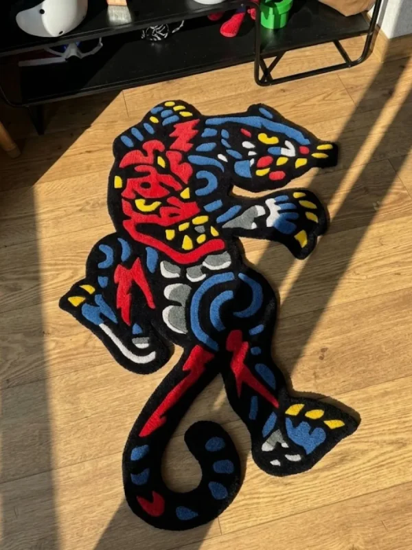 Angled perspective view of the vibrant Phantom Panther neo-traditional tattoo rug, perfectly showcasing its dynamic shape, sharp claws, and striking red and blue color palette on a warm hardwood floor.
