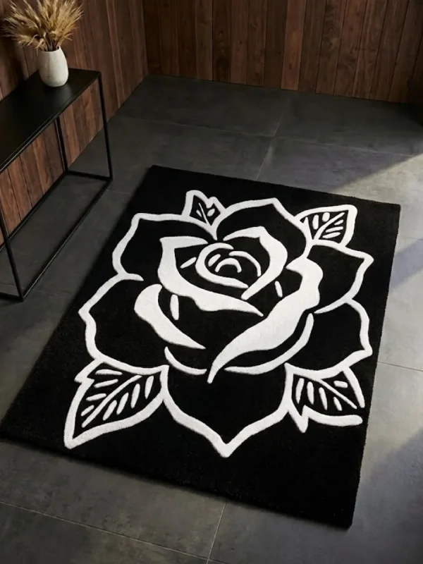 Perspective view of the Phantom Rose black and white rug styled in a modern entryway with dark slate tile flooring, wood paneling, and a minimalist black console table, bathed in a beam of natural sunlight.