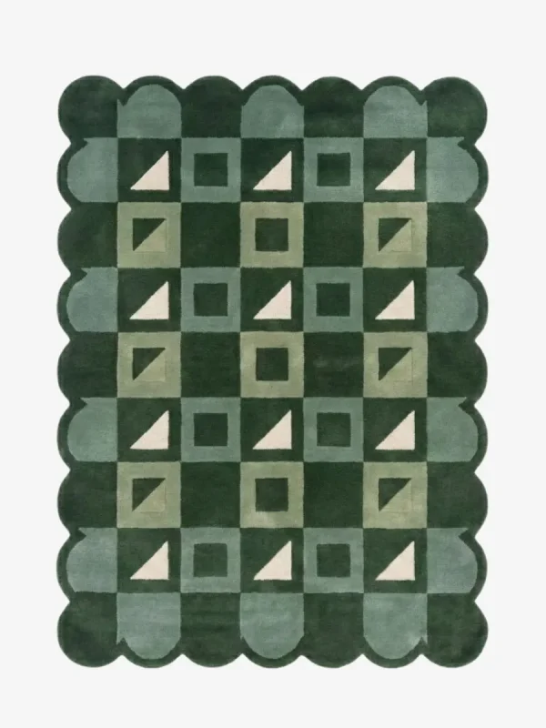 Top-down view of the Pine Patchwork rug against a white background, featuring a repeating geometric patchwork pattern of squares and triangles in shades of dark green, soft green, and cream, framed by a continuous dark green scalloped border.