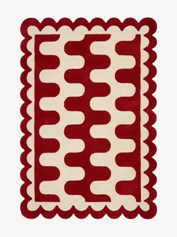 Top down view of the Ruby Weave rug featuring a deep red wool background with a bold cream wavy geometric pattern and custom scalloped edges.