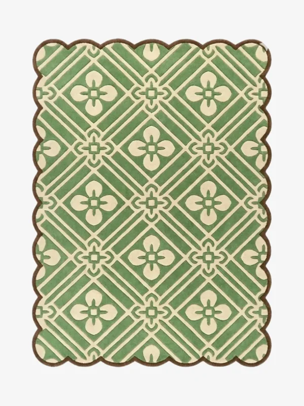 Top-down view of the Sage Dream rug against a white background, featuring an intricate repeating geometric lattice pattern with four-petal floral motifs in cream over a sage green background, framed by a continuous brown scalloped border.