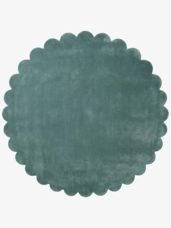 Top down flat lay view of the Sagewave circular rug showing the soft teal green wool color and scalloped border.