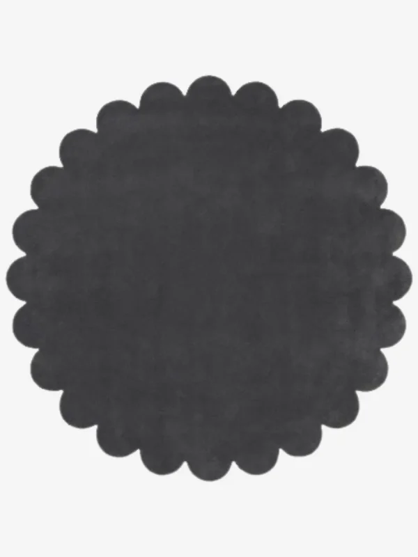 Top down flat lay view of the Slate Cloud round rug showing the dark charcoal grey wool color and scalloped border.