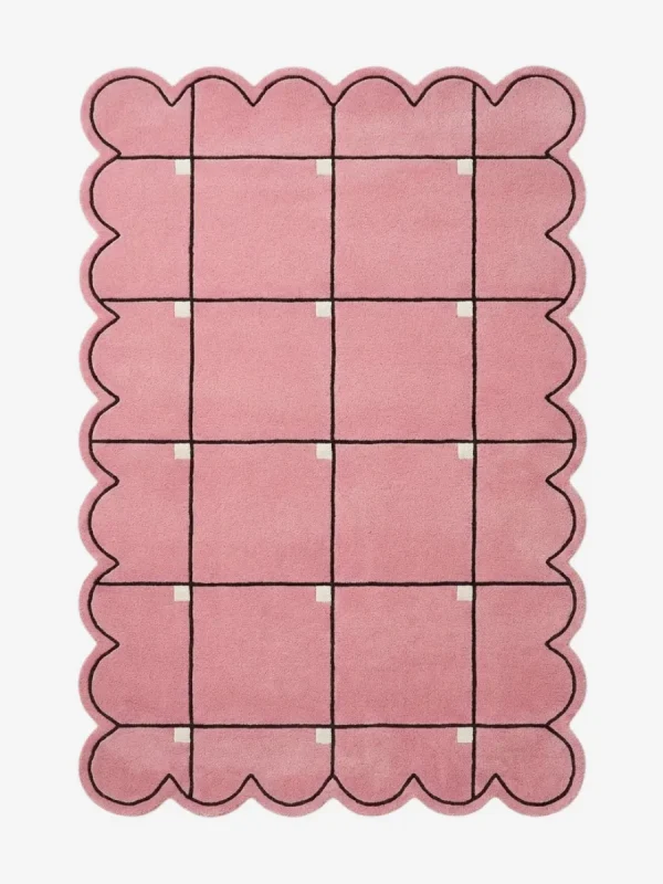Top down view of the Soft Depth rug featuring a soft pink wool background with a delicate dark grid pattern accented by small white squares and custom scalloped edges.