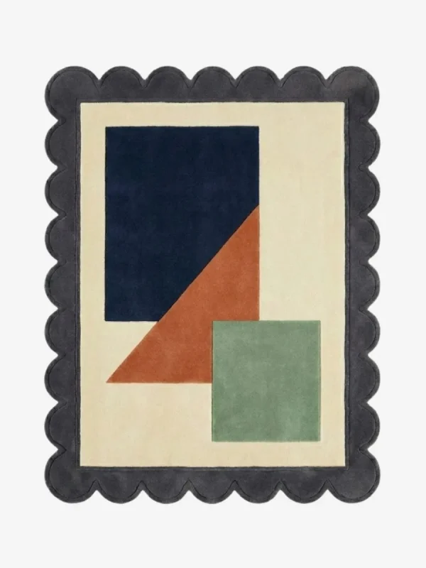 Top down view of the Stone Leaf rug featuring a calming geometric design with earthy stone grey and sage green accents on a plush wool background, finished with custom scalloped edges.