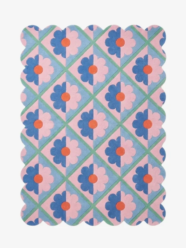 Top down view of the Sugar Trellis rug featuring a retro diamond grid pattern with pink and blue floral motifs and scalloped edges on a hand tufted wool background.