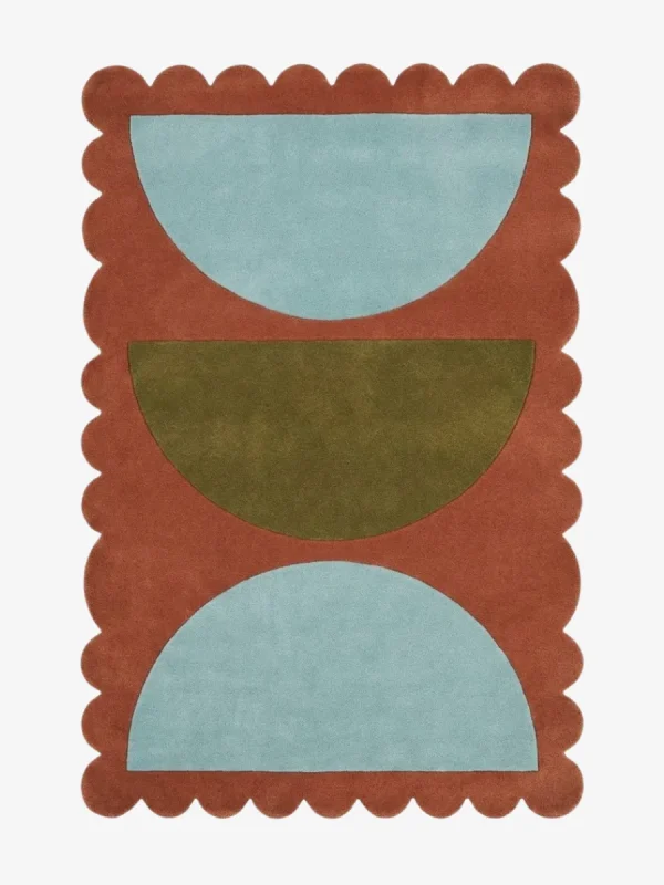 Top down view of the Sunbaked Form rug featuring a bold geometric pattern with large light blue and olive green semi-circles on a terracotta rust wool background with scalloped edges.