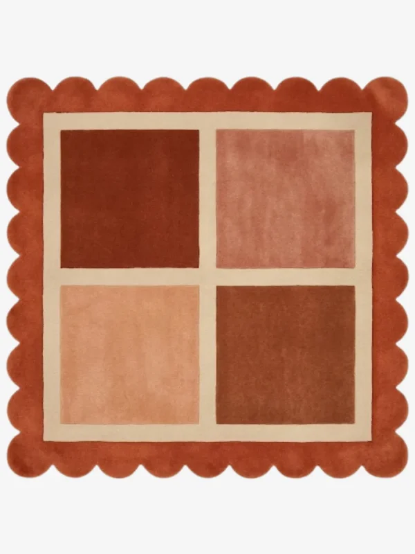Top-down view of the square Sunset Panel rug featuring a cream grid with four color-blocked squares in shades of rust and peach, framed by a thick rust orange scalloped border.