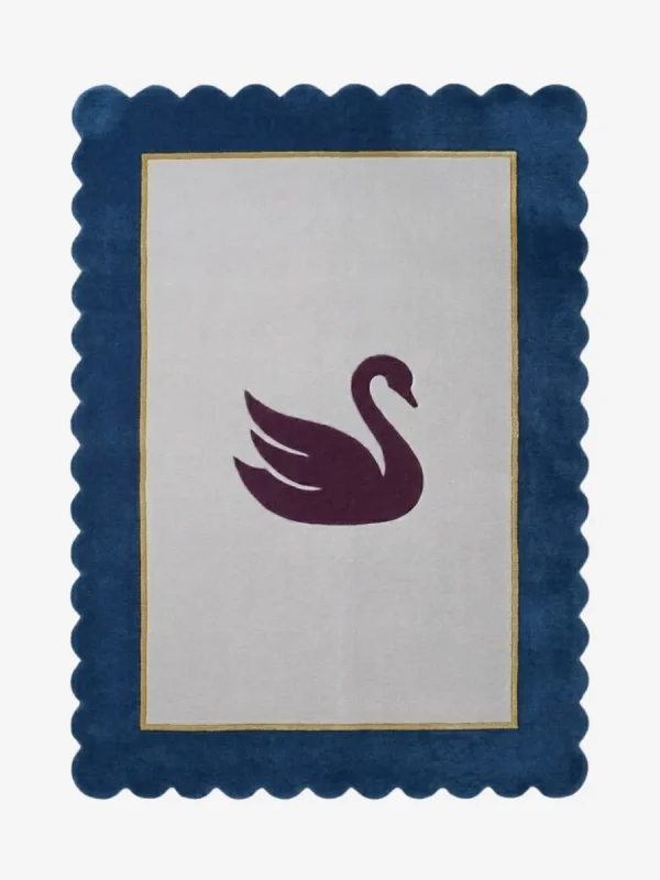 Top-down view of the Swan Crest hand-tufted wool rug featuring a central dark purple swan silhouette on a light grey rectangular field, framed by a thin gold line and a bold navy blue scalloped border.