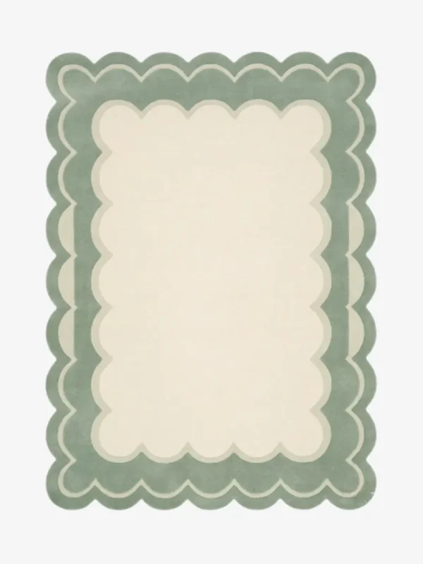 Top-down view of the rectangular Sylvena Crest rug, featuring a large solid cream center framed by a delicate inner wavy contour line and a thick, soft sage green scalloped outer border.