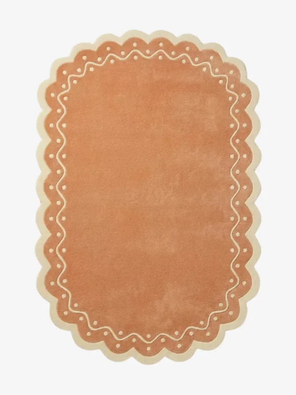 Top down view of the Terra Manor rug featuring a warm rust terracotta background with a decorative cream border containing a wavy line and polka dots.