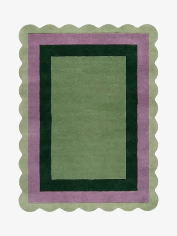 Top-down view of the Trimmed Forest rug against a white background, featuring a classic rectangular design with concentric color-block borders in light green, muted purple, and dark forest green, wrapped around a solid light green center and framed by a continuous light green scalloped edge.