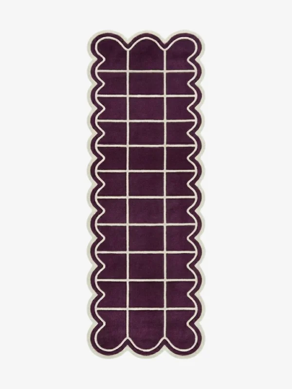 Top-down view of the Velquor Vane runner rug, featuring a rich plum purple background with a crisp cream geometric grid pattern, framed by a deeply contoured wavy cream border.